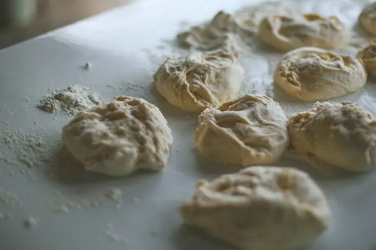 Close-up view of raw dough balls on a flour-dusted table, soft and ready for baking.